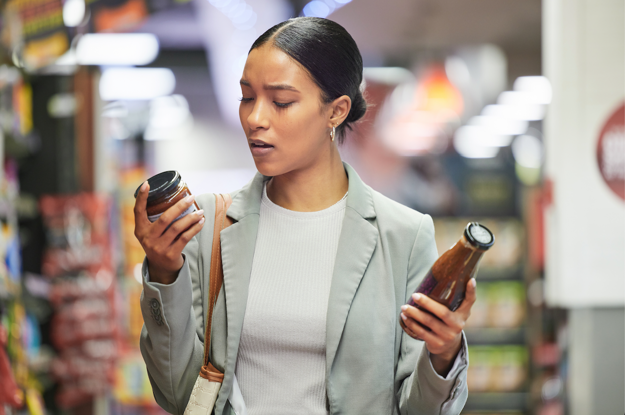 Shopper comparing two products while reading their labels