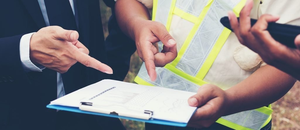 People reviewing a product document and requirements on a clipboard