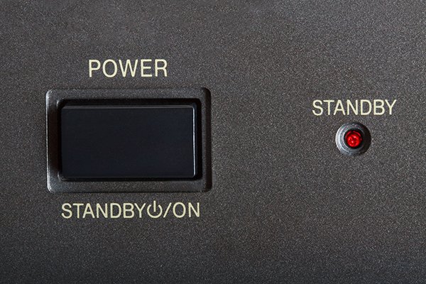 A person measuring standby power from a connected electronic device with a plug-in power meter