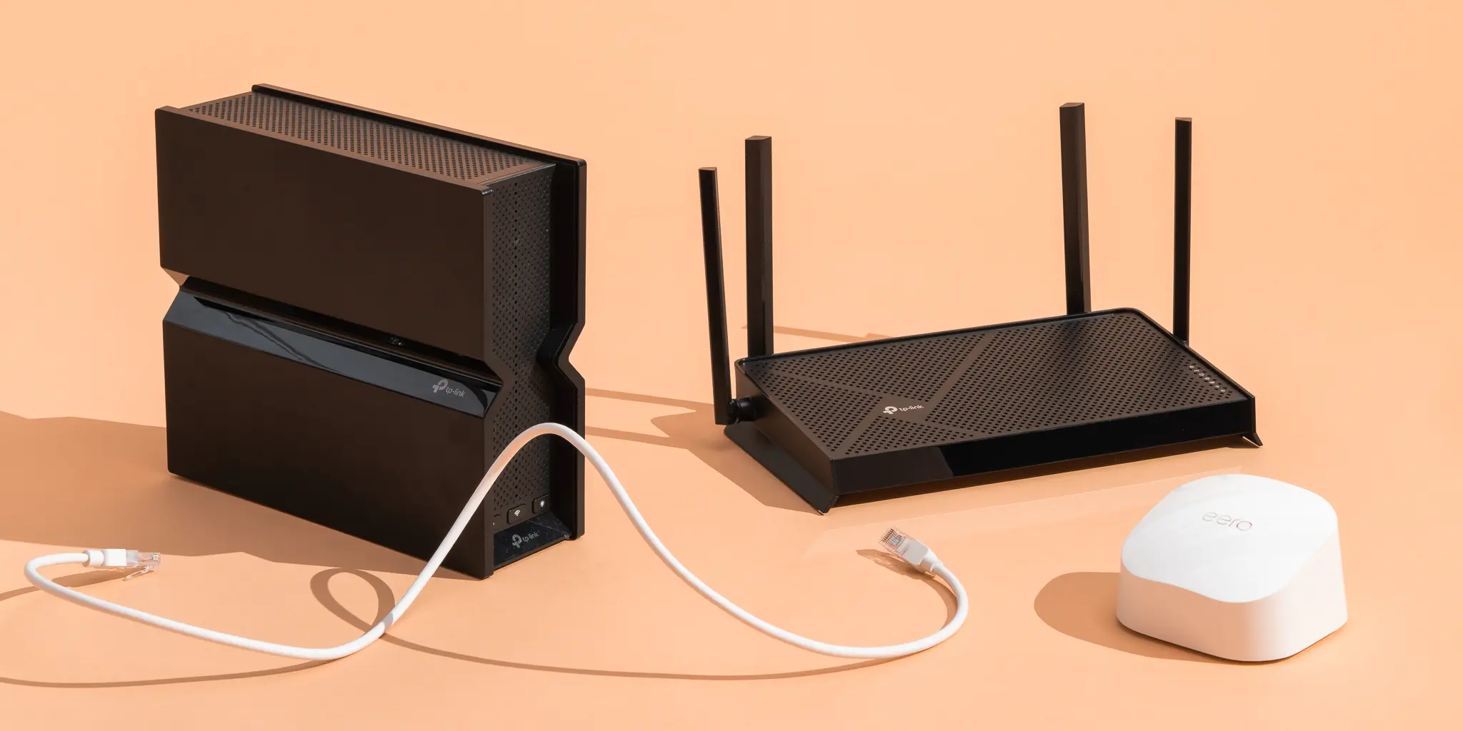 A wireless router and mesh network equipment arranged on a warm peach background
